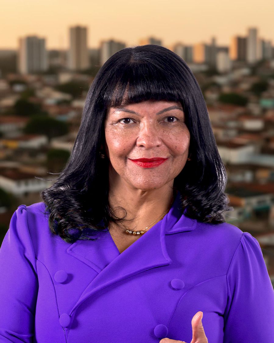 Telma Rufino, sorrindo, com blazer roxo, diante da paisagem urbana do Distrito Federal